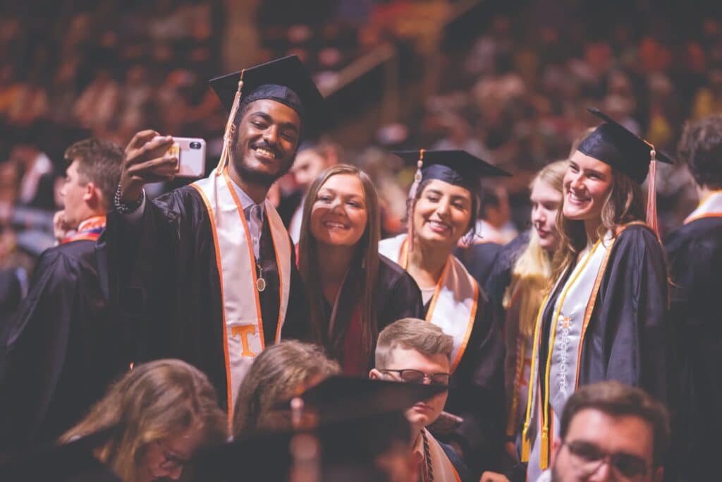 Students smiling at commencement ceremony.