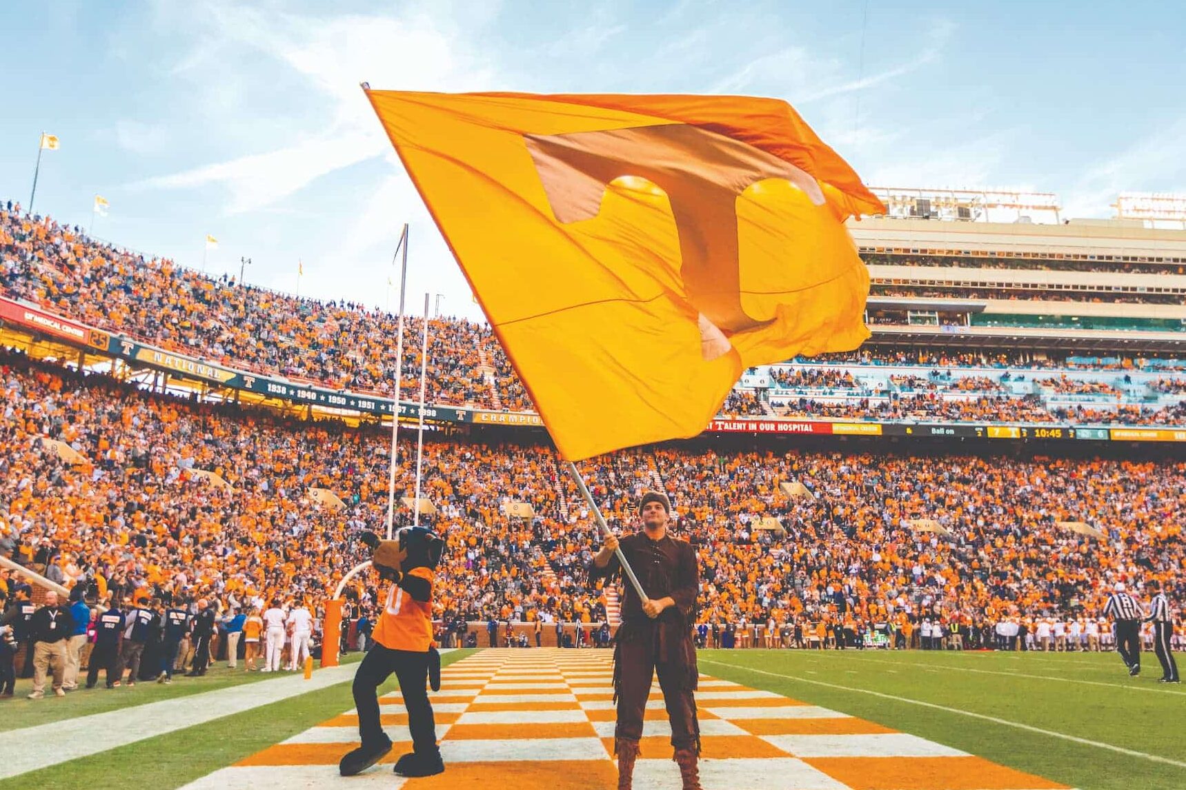 UT Mascots waving UT Flag